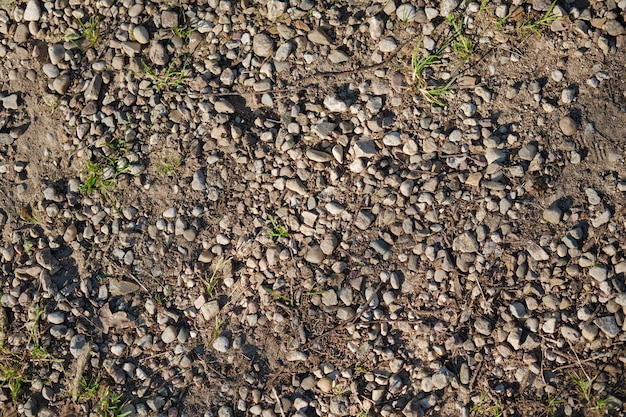 Vista dall'alto del frammento di strada sterrata. Terra asciutta con pietre. Fondo strutturato naturale astratto.