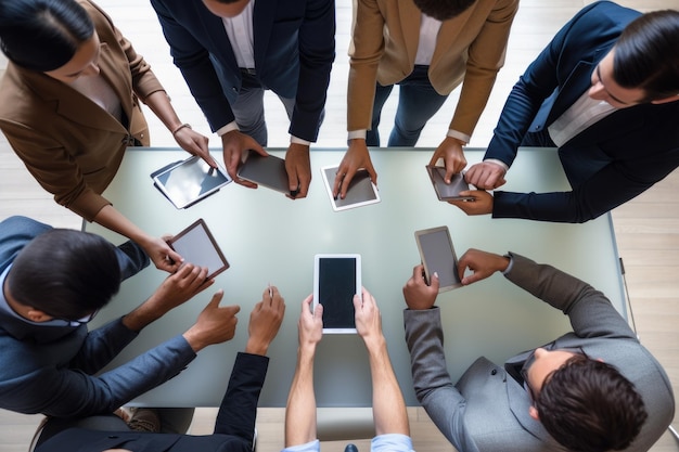 Vista dall'alto del gruppo che utilizza il tablet moderno sul tavolo di legno dell'ufficio