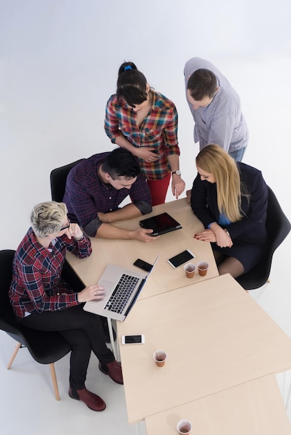 Vista dall'alto del gruppo di uomini d'affari di avvio multietnico durante la riunione di brainstorming negli interni moderni e luminosi dell'ufficio