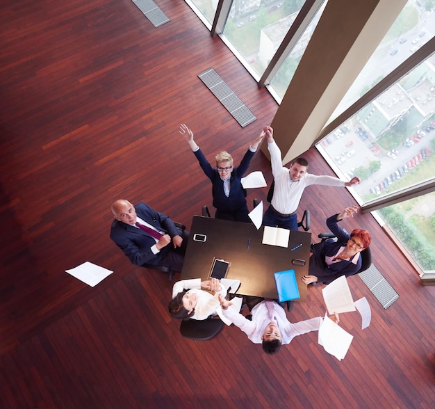 vista dall'alto del gruppo di uomini d'affari sulla riunione che lancia documenti in aria