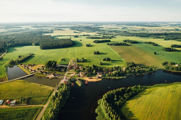 Vista dall'alto del lago in un campo verde a forma di ferro di cavallo e un villaggio nella regione di Mogilev