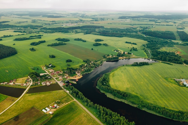 Vista dall'alto del lago in un campo verde a forma di ferro di cavallo e un villaggio nella regione di Mogilev