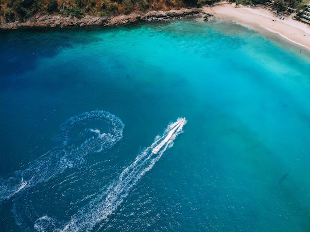 Vista dall'alto del motoscafo, che lascia traccia sulla superficie dell'acqua blu; concetto di navi.