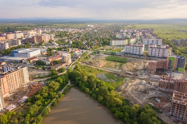 Vista dall'alto del paesaggio urbano in via di sviluppo urbano con alti edifici di appartamenti e case di periferia