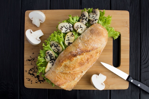 Vista dall'alto del panino con funghi prataioli e foglie di lattuga