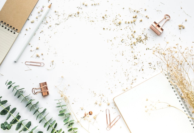 Vista dall'alto del piano di lavoro con accessori mock up e fiore secco.