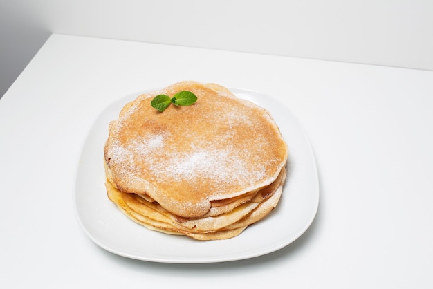 Vista dall'alto del piatto con frittelle vegane sottili su sfondo grigio chiaro