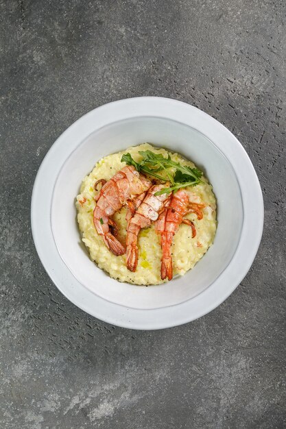 Vista dall'alto del piatto con risotto ai gamberi su fondo grigio cemento