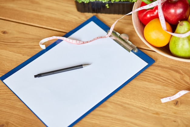 vista dall'alto del posto di lavoro nutrizionista dietista con spazio vuoto per piano dietetico penna metro a nastro e ciotola con frutta e verdura sane assistenza sanitaria e dieta giusta nutrizione e benessere dimagrante