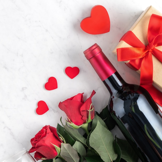 Vista dall'alto del regalo di San Valentino con rose e vino, concetto di design festivo per un pasto speciale per le vacanze