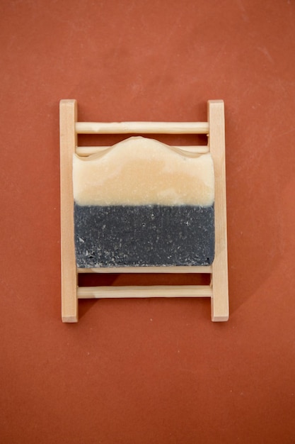 Vista dall'alto del sapone biologico fatto in casa a base di oli naturali e latte su sfondo marrone. Minimalismo.