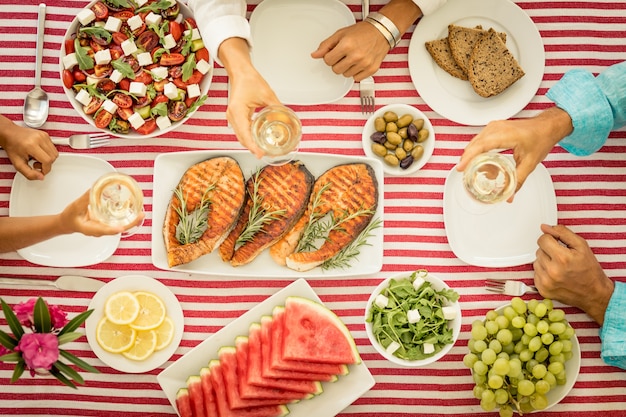 Vista dall'alto del tavolo con pesce, insalate, frutta e verdura