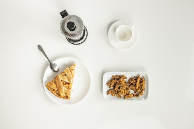 Vista dall'alto del tavolo minimalista con pranzo di lavoro con caffè, cereali e torta di mele.