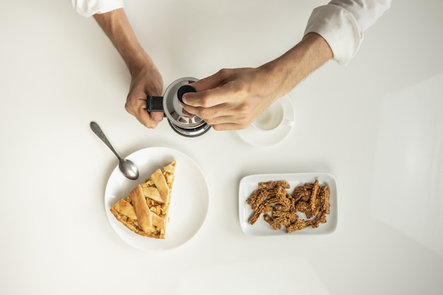 Vista dall'alto del tavolo minimalista con pranzo di lavoro con caffè, cereali e torta di mele.