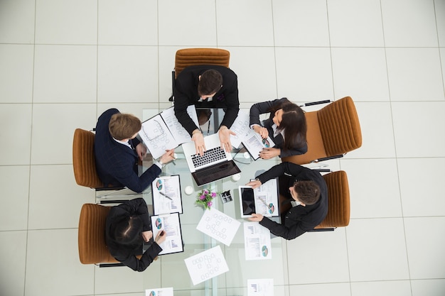 Vista dall'alto del team aziendale di successo che discute di nuovi schemi di marketing sul posto di lavoro in ufficio. La foto è uno spazio vuoto per il testo