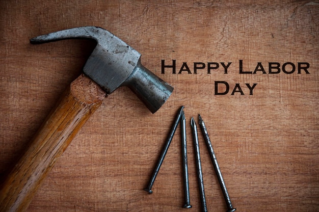 Vista dall'alto del testo sulla scrivania in legno Happy Labor Day con sfondo martello e chiodi