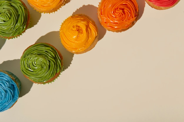 Vista dall'alto deliziosa glassa per cupcake arcobaleno ancora in vita