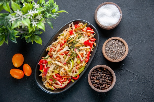 Vista dall'alto deliziosa insalata di peperoni all'interno del piatto lungo con condimenti sfondo scuro pasto dieta colore salute pane cibo piatto orizzontale