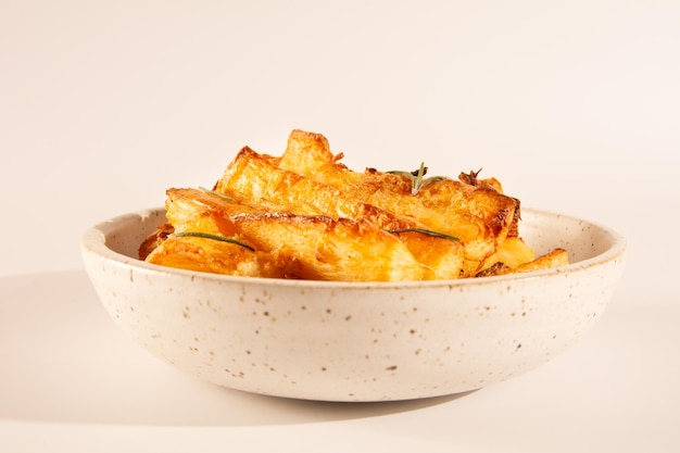 Vista dall'alto Deliziosa manioca fritta in ciotola di ceramica bianca artigianale su sfondo bianco per studio