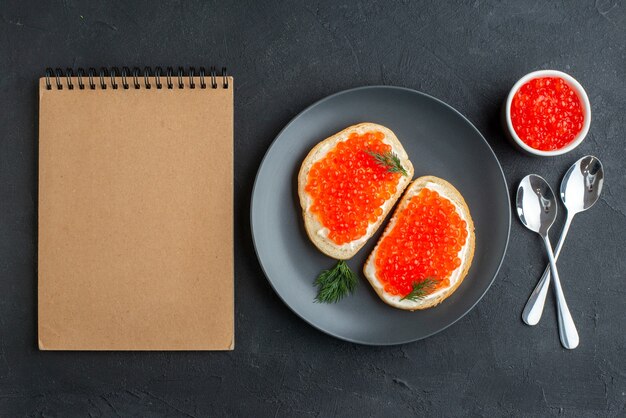 vista dall'alto deliziosi panini al caviale all'interno del piatto su superficie scura