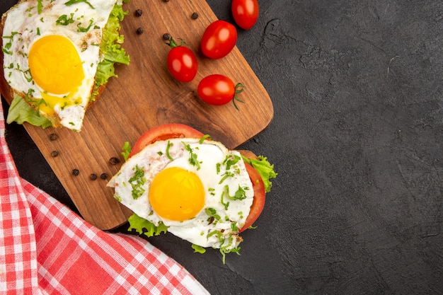 vista dall'alto deliziosi panini con uova e pomodori su sfondo scuro pasto pane pranzo bollire colazione frittata di uova