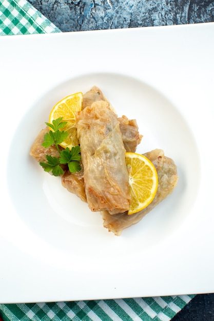 vista dall'alto delizioso cavolo dolma con limone all'interno della piastra su sfondo scuro pasto cucina cena cibo piatto calorico pane