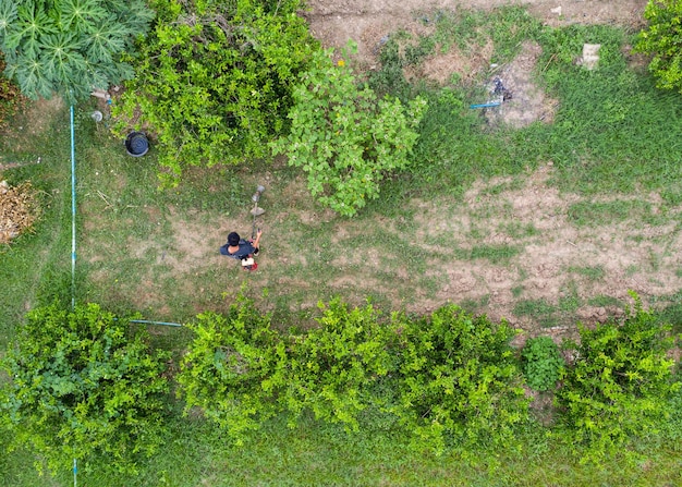 Vista dall'alto dell'agricoltore che falcia con il tosaerba