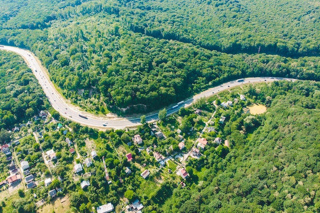 Vista dall'alto dell'autostrada vicino al villaggio. foresta intorno