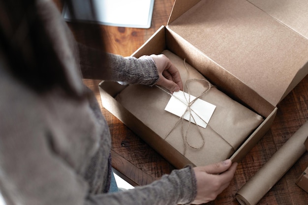 Vista dall'alto dell'imprenditrice che lavora all'imballaggio dell'ordine per la spedizione al cliente