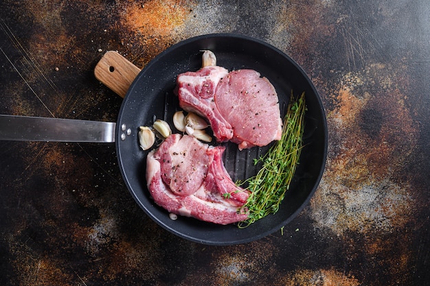 Vista dall'alto della bistecca di braciola di maiale biologico crudo con ingredienti