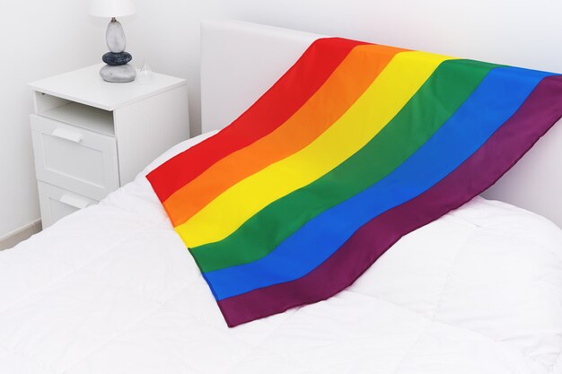 Vista dall&#39;alto della comunità LGBT bandiera arcobaleno sul letto bianco in camera da letto