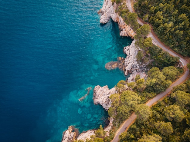 Vista dall'alto della costa rocciosa del mare Adriatico cristallino, ripresa dal drone