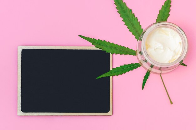 Vista dall'alto della crema di canapa alla cannabis con foglia di marijuana con bordo vuoto nero per mockup di testo