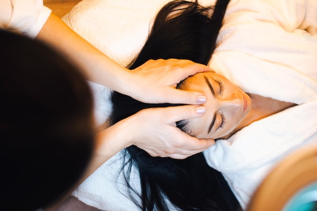 Vista dall'alto della donna caucasica che riceve un trattamento di massaggio termale presso il salone di bellezza spa...