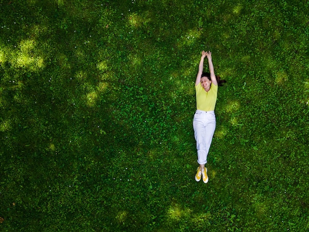 Vista dall'alto della donna sdraiata sull'erba verde estate