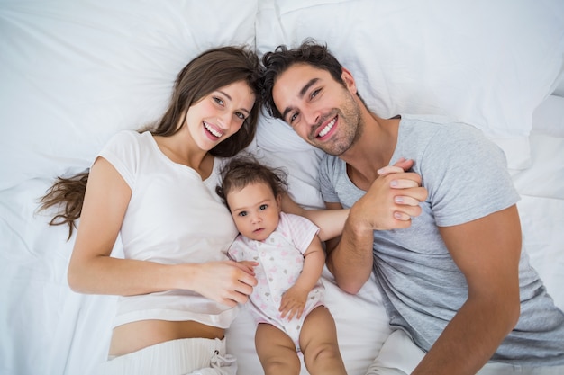 Vista dall'alto della famiglia felice sdraiato sul letto