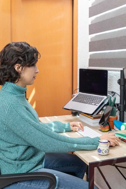 Vista dall'alto della giovane donna latina che lavora alla sua scrivania a casa con il suo computer Concetto di ufficio domestico