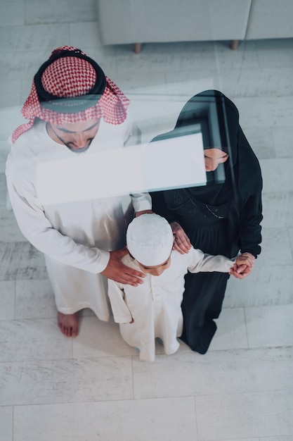 Vista dall'alto della giovane famiglia musulmana araba che indossa abiti tradizionali.