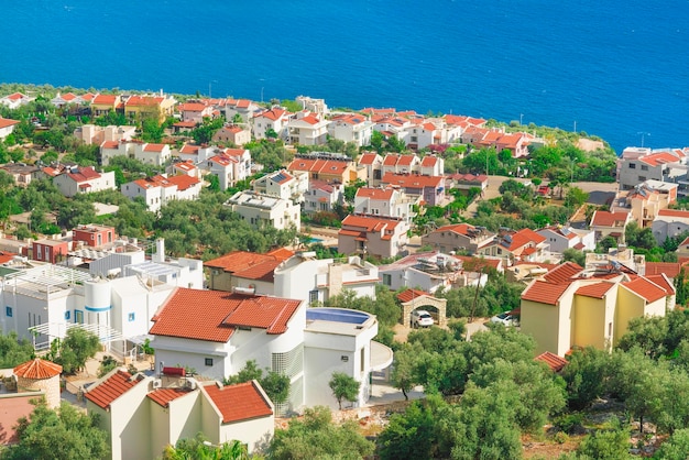 Vista dall'alto della località turistica con tetti di tegole rosse e facciate bianche vicino al mare blu