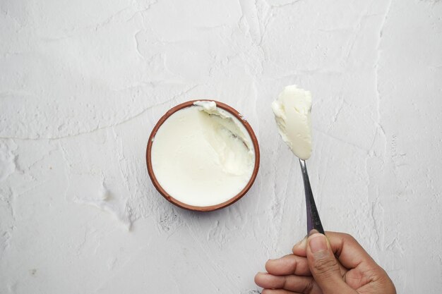 Vista dall'alto della mano dell'uomo che mangia yogurt fresco da una ciotola