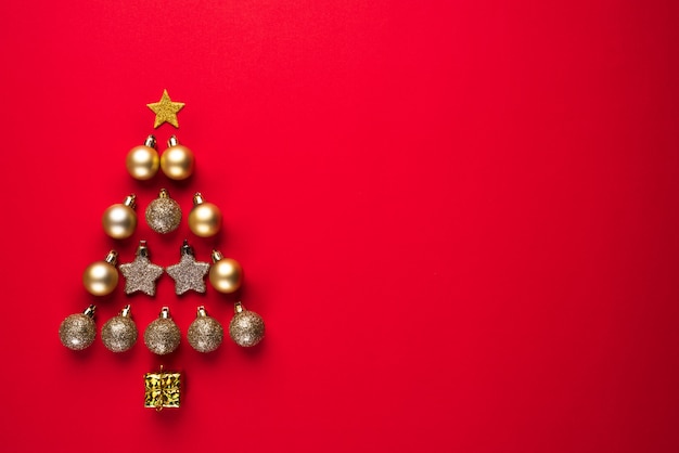 Vista dall&#39;alto della palla d&#39;oro e la stella in forma di albero di Natale su sfondo rosso.