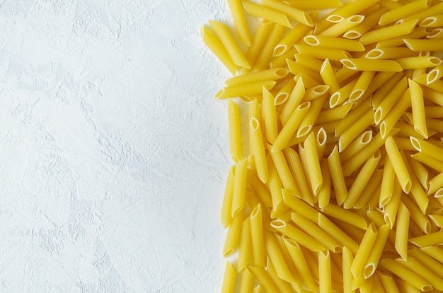 Vista dall'alto della pasta di penne sulla superficie chiara