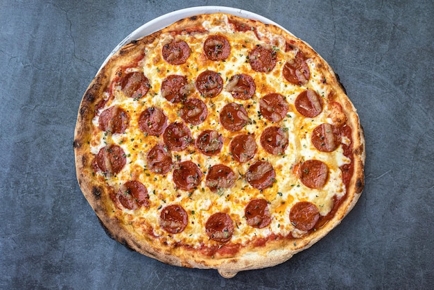 Vista dall'alto della pizza ai peperoni caldi su uno sfondo rustico