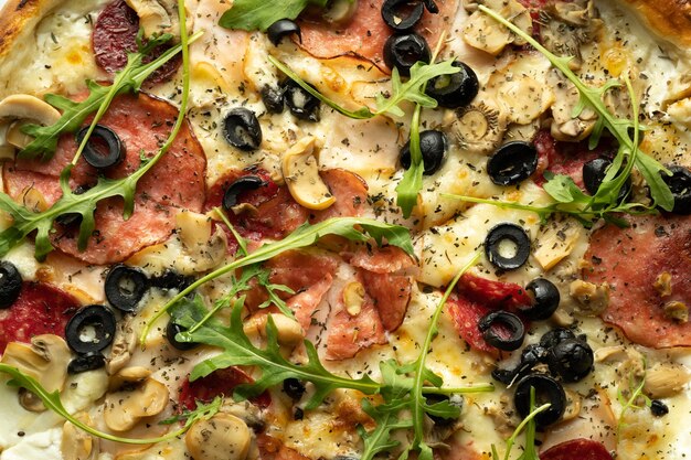 Vista dall'alto della pizza con olive, salame, rucola e formaggio in una scatola. Consegna degli ordini da una pizzeria.