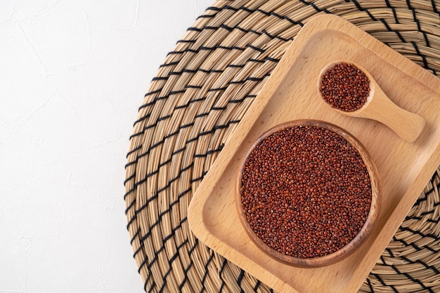 Vista dall'alto della quinoa rossa organica in una ciotola sul fondo bianco della tavola