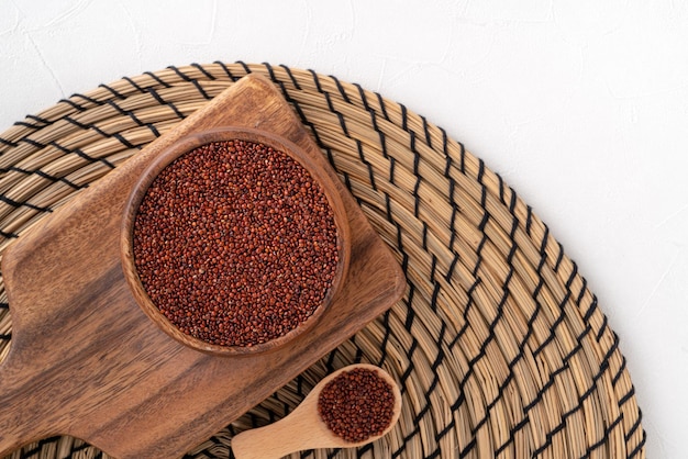 Vista dall'alto della quinoa rossa organica in una ciotola sul fondo bianco della tavola