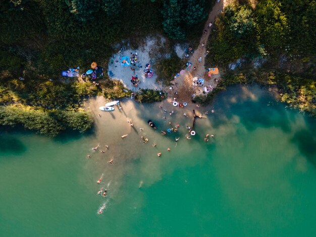 Vista dall'alto della spiaggia di perdita di acqua blu persone che si divertono a nuotare prendendo il sole in estate