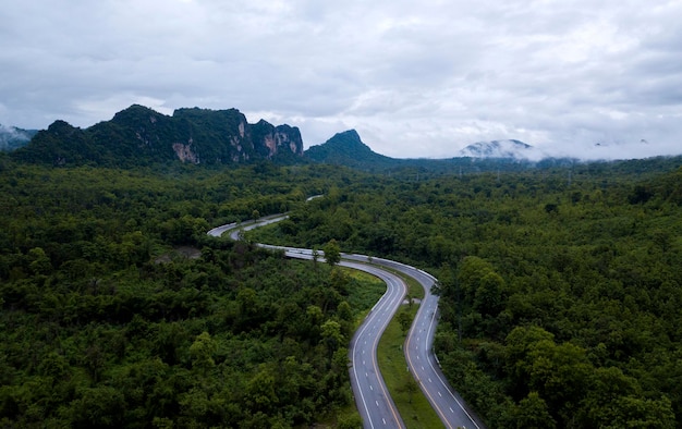 Vista dall'alto della strada di campagna che passa attraverso la foresta verde e montagna