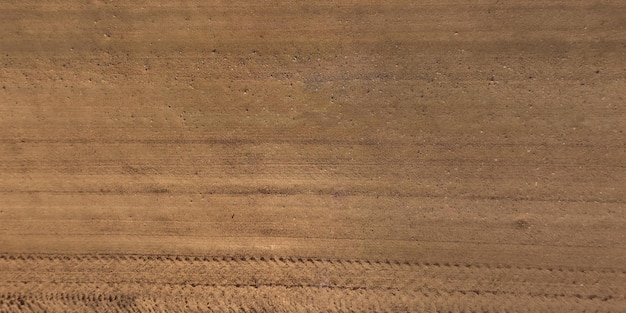 Vista dall'alto della superficie della strada sterrata fatta di piccole pietre e sabbia con tracce di pneumatici per auto