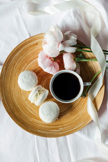 vista dall'alto della tazza di caffè con macarons e fiori